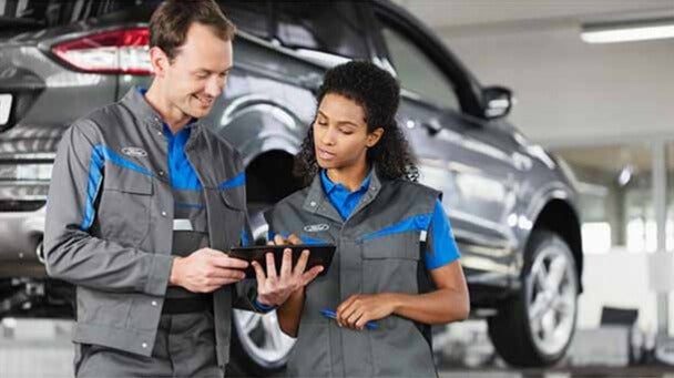 Ford service technicians reviewing vehicle information on a tablet