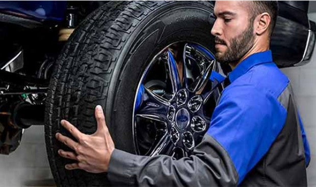 Ford service technician installing a tire